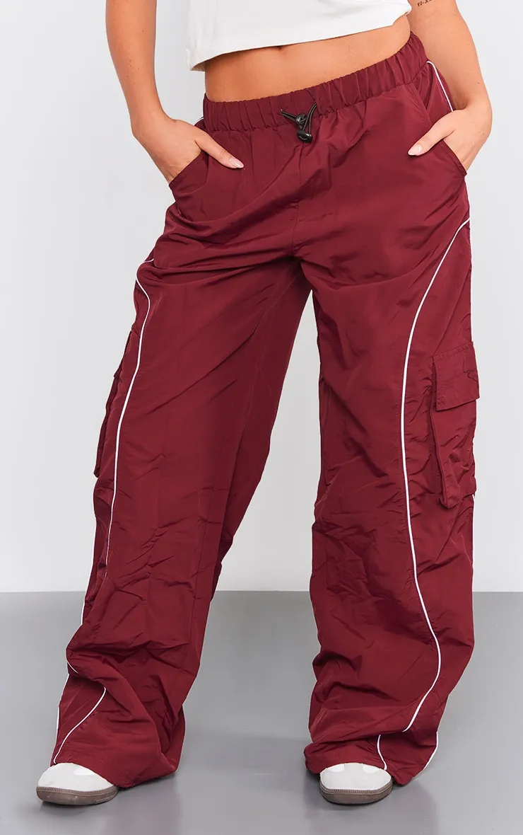 Pantalon cargo rouge cerise à détail coutures et cordons ajustables sur la taille