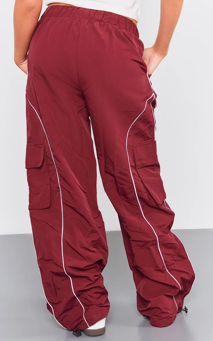 Pantalon cargo rouge cerise à détail coutures et cordons ajustables sur la taille