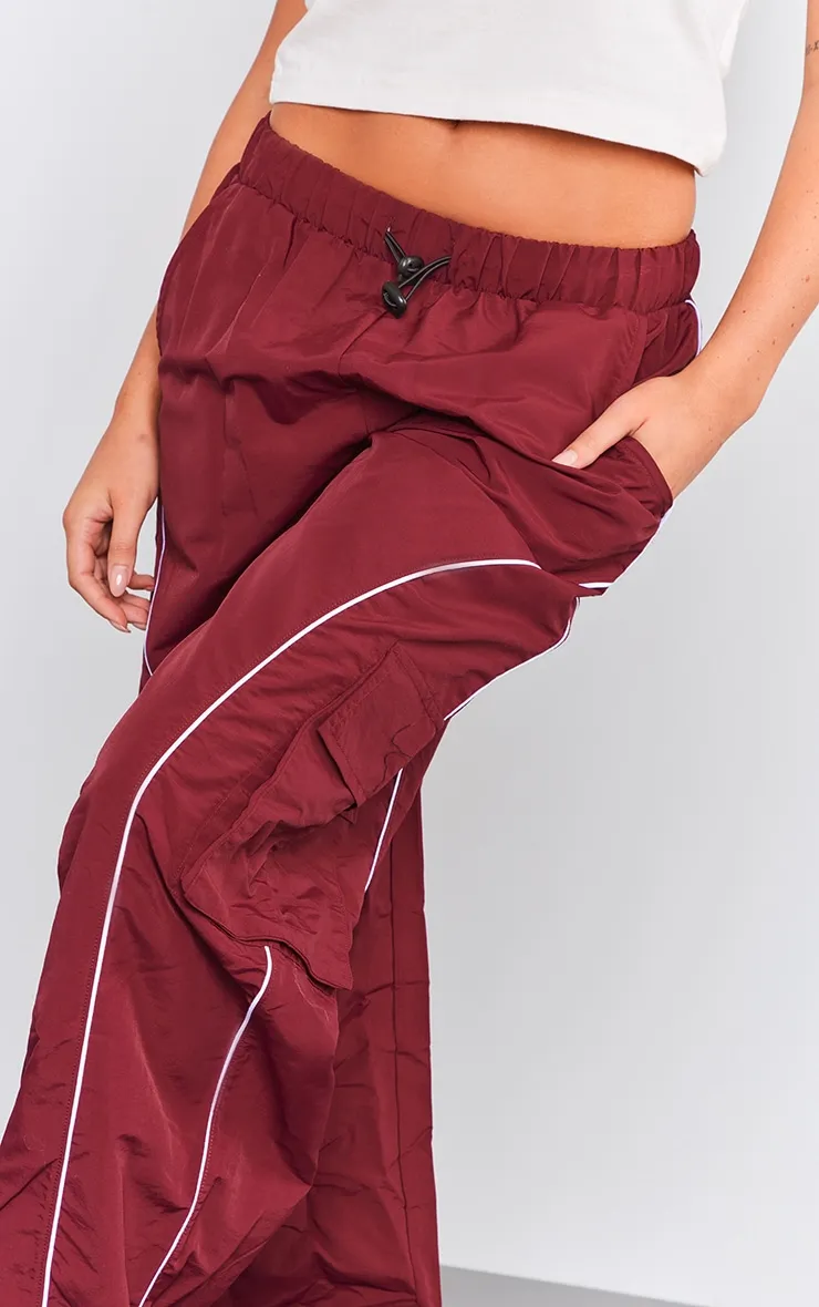 Pantalon cargo rouge cerise à détail coutures et cordons ajustables sur la taille